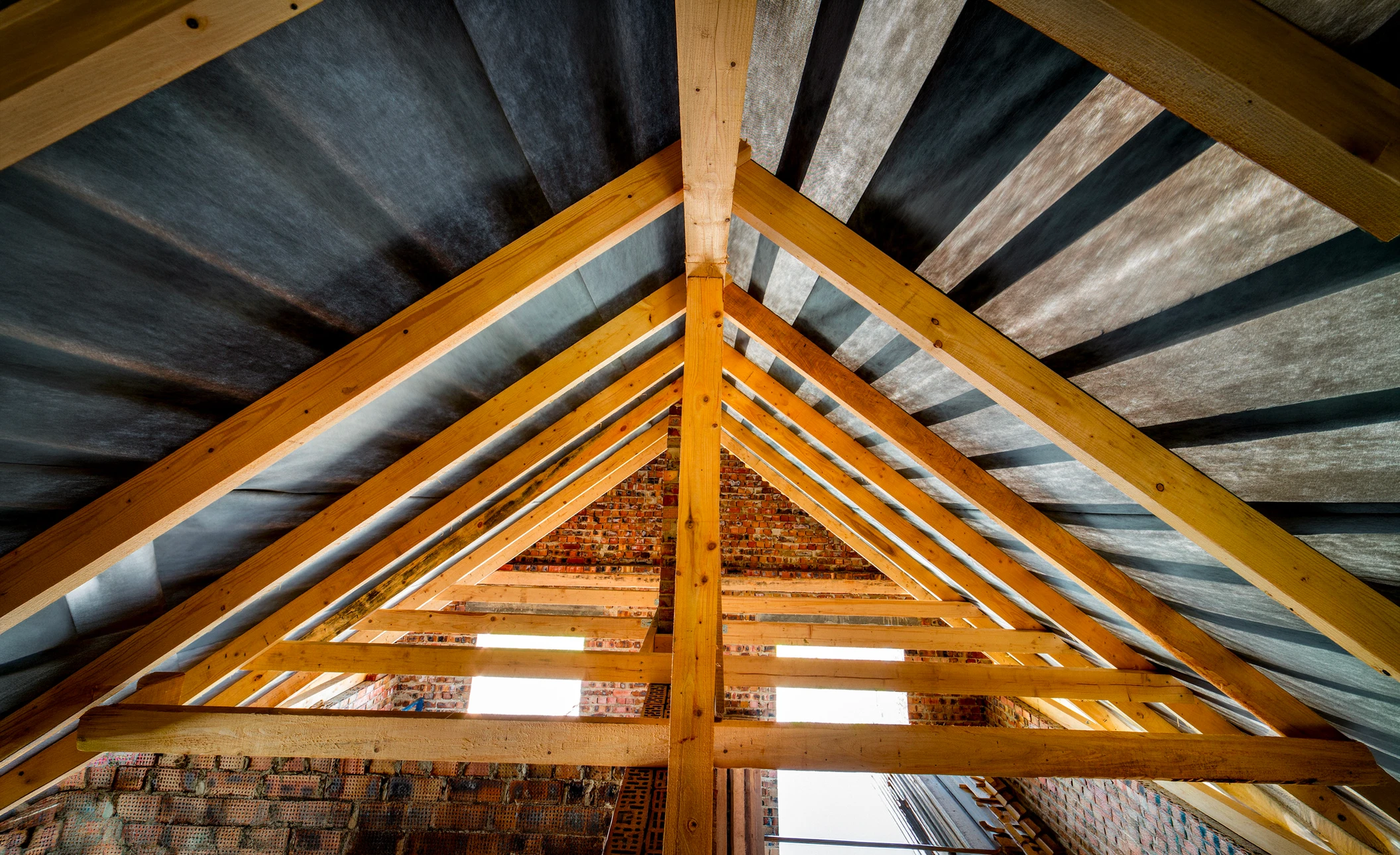 Artisan travaillant le bois dans un atelier, utilisant une râpe pour façonner une pièce de bois courbée maintenue dans un étau