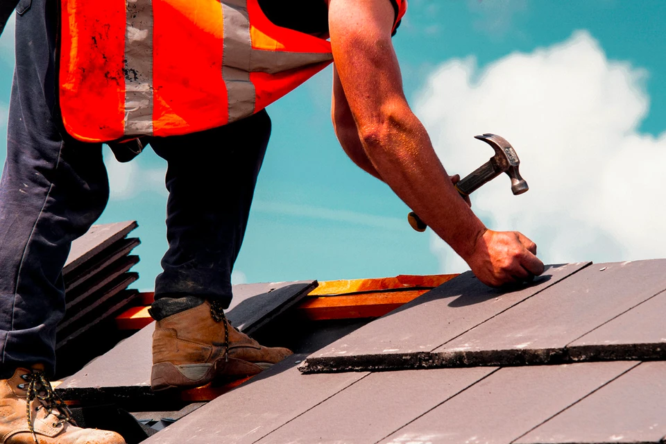 Portrait d'une jeune femme charpentier ponçant du bois et construisant un meuble fait à la main dans un atelier