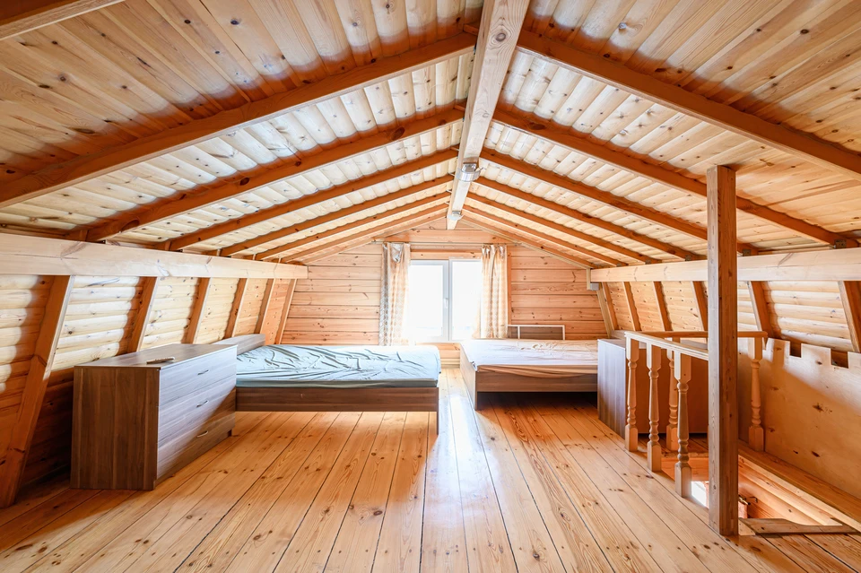 Famille de quatre personnes assise sur un tapis dans un salon lumineux, parents et deux enfants riant ensemble dans une atmosphère détendue et chaleureuse
