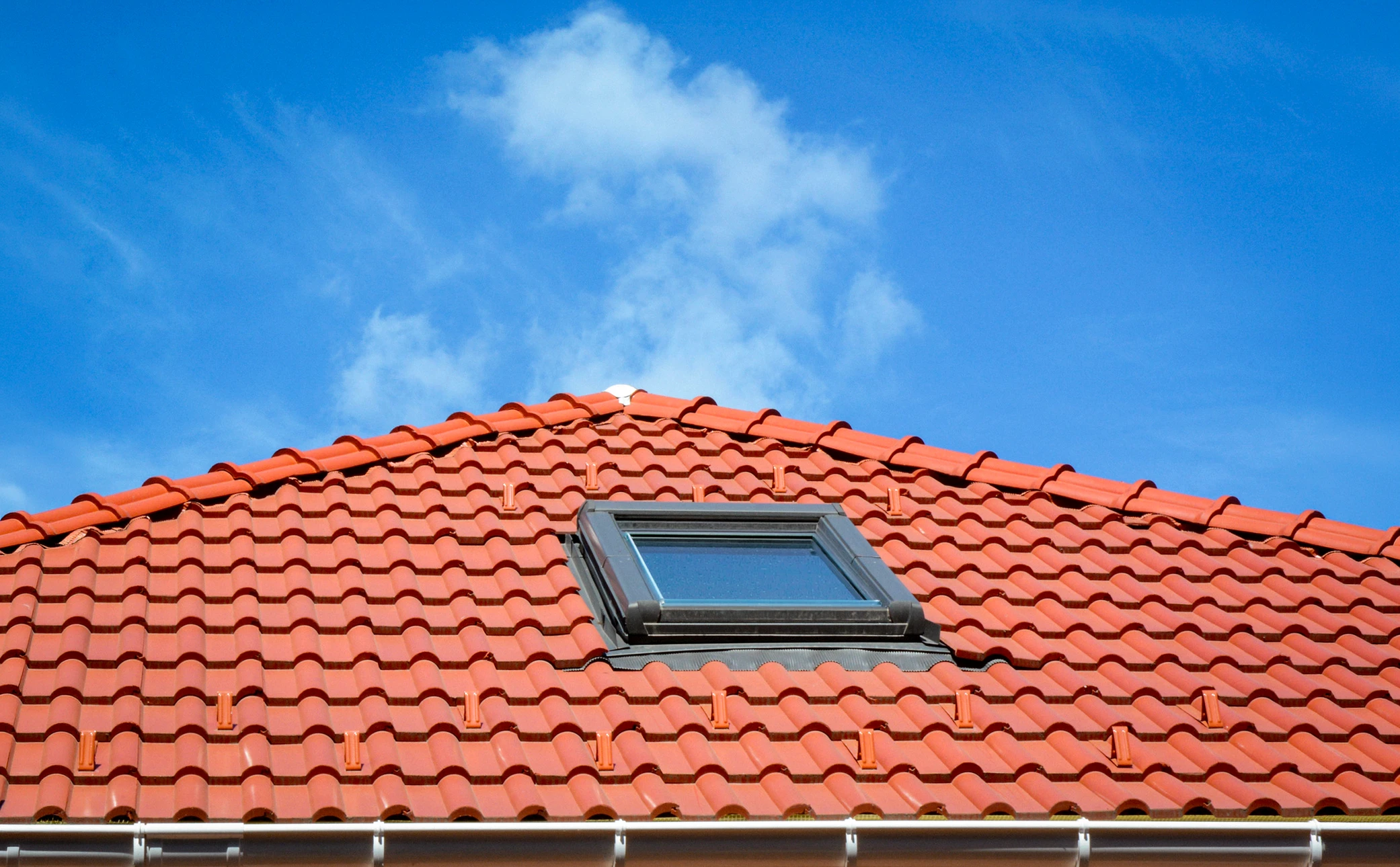 Maison individuelle contemporaine illuminée au crépuscule avec terrasse aménagée, mobilier extérieur et jardin fleuri